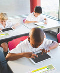 Students using tablets with Stick On Nameplate Pockets For Desks, 40 Pack, Clear Adhesive Covers Measuring 4.7 X 14.2 Inches
