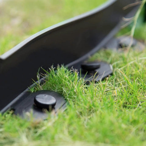 Close-up of 40 Ft Garden Landscape Edging Kit with 40 Spikes Black 2 Inch Tall Paver Edging installed in grass