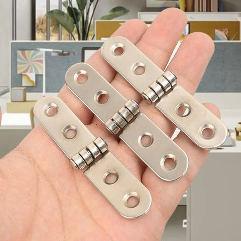 Hand holding Six Piece Folding Door Hinges Set With Rust Resistant Finish Heavy Duty And Easy Install For Furniture And Decor Bulletproof Build Iron Construction 7.8 By 1.7 Cm Great For Cabinets Doors And DIY Projects against blurred interior background