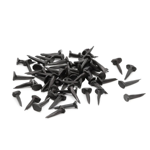 Solid As A Rock Half Inch Black Steel Upholstery Tacks To Nail Down Muslin And Fabric Covers Smooth Dome Heads in a scattered pile.