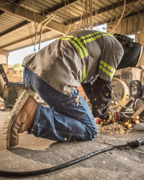 Worker kneeling while wearing Wingshooter ST 6 Inch Waterproof Non Metallic Safety Toe Work Boot Men Amber Size 10.5 D Medium on site.
