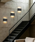 Modern Wood LED Linear Wall Sconce, Mini Up Down Wall Mount Light,Hardwired,UL Listed,Wood Wall Lighting Fixture for Bedroom, Living Room,Stairway, Hallway, (Black) 2 Pack installed on a concrete wall next to a staircase.
