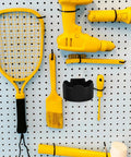 Black Plastic Aerosol Can Holder Wall Mount Organizer for Spray Bottles and Cans on a pegboard with yellow tools