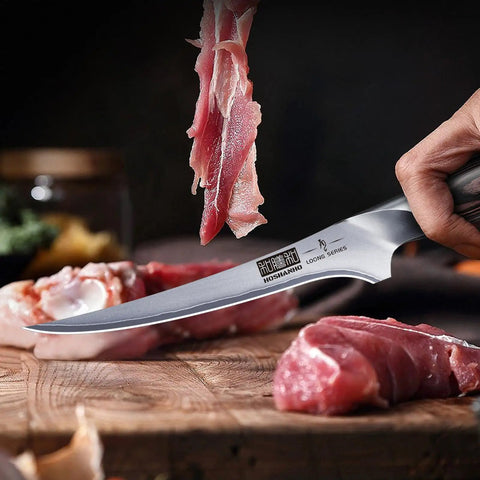 7 Inch Fillet Knife Razor Sharp Boning Knife In High Carbon Stainless Steel slicing meat with precision on a wooden board.
