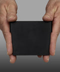 Close-up of hands holding a black plastic width divider for 4 inch tall shelf bins, fits models 30120 30128 and 30124
