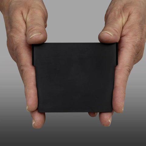 Close-up of hands holding a black plastic width divider for 4 inch tall shelf bins, fits models 30120 30128 and 30124