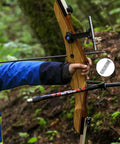 Archer holding bow with 24 Pack Aluminum Arrow Inserts For Carbon Shafts.244 Inch / 6.20mm in forest setting