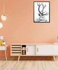 Modern living room with minimalist furniture, deer artwork on peach wall, wooden sideboard, plants, and pendant lights.