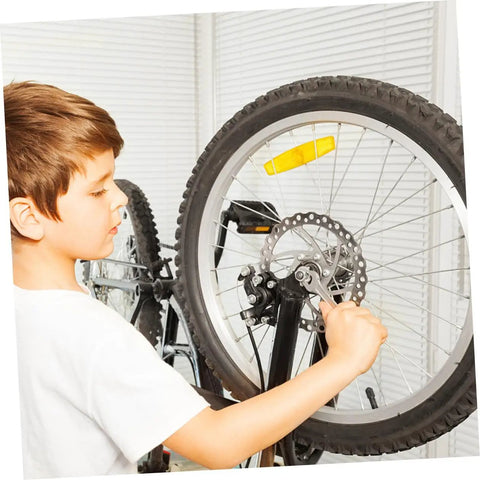 Child servicing a mountain bike wheel with a focus on the Complete Mechanical Disc Brake Set For Mountain Bikes Featuring Front And Rear 160 Mm Silver Aluminum Rotors Dual Adjustment Calipers Solid Pads And Ready To Roll Cable Kit.