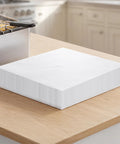 No Sweat Heavy Duty 100 Pack Deep Fryer Filter Papers For Commercial Kitchens 15 By 13 Inch stacked on a kitchen counter.