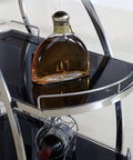 Rustic Industrial Kitchen Wine Storage Cart With Heavy Duty Steel Frame Super Smooth Swivel Casters And Wide Glass Shelves showing a round bottle on a glass shelf.