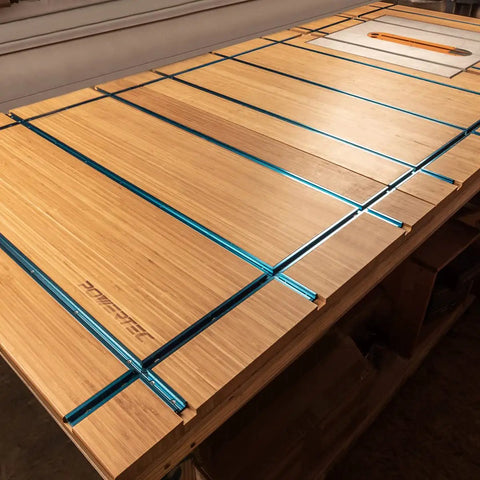 Wooden workbench with blue aluminum 3 Inch T Track Intersection Kit with predrilled mounting holes and wood screws for DIY woodworking jigs.