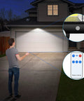 Man using Ultra Bright Solar Motion Lights Outdoor With Remote Control to illuminate a garage with 320 COB LEDs.