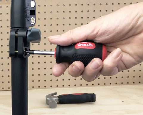 Using the Tiny But Mighty Stubby Tool Set For Small Hands And Tight Spaces Includes Mini Hammer, Mini Screwdriver Set And Mini Wrench In Bright Red on a workspace with pegboard.