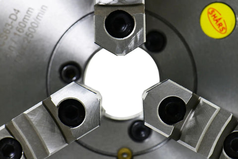 Close-up view of Top Shelf Eight Inch Three Jaw Self Centering Scroll Lathe Chuck, showcasing three jaws and steel construction.
