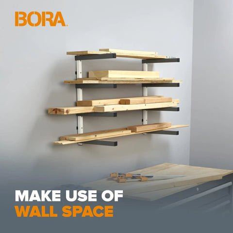 Heavy Duty Four Tier Lumber Storage Rack For Garage And Workshop Space Saving Metal Board Shelf For Plywood Pipes And Building Materials White Gray mounted on wall with timber support.