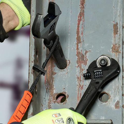 Heavy Duty Adjustable Spud Wrench 16 Inch Long With 1 5 8 Inch Opening Fits Heavy Nuts And Bolts Up To 1 Inch Forged In USA Tether Hole For Safe Work Lanyard Compatible Built For Tough Job Sites being used on metal job site