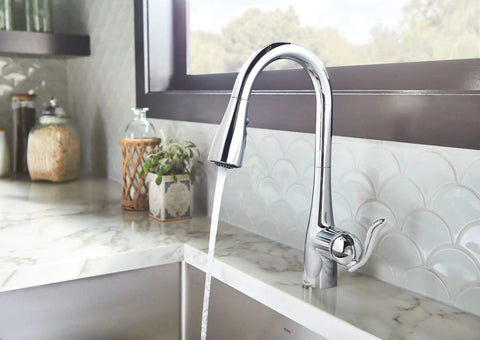 Arbor Chrome One-Handle Kitchen Faucet with Pull Down Sprayer Featuring Power Boost and Reflex in use at a modern kitchen sink