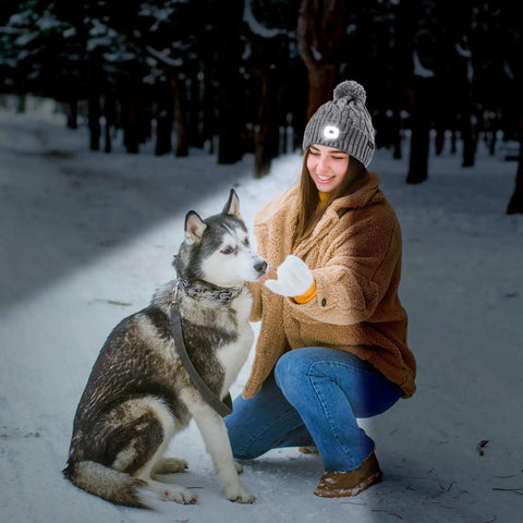 Woman wearing Unisex Winter Beanie With Built In LED Light Headlamp Hat USB Rechargeable For Men And Women, cozy knit cap with dog