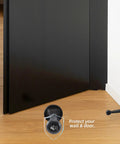 Super Sturdy Three Inch Heavy Duty Door Stops In A Spiffy Twelve Pack Featuring Dang Tough Solid Zinc Alloy Build And A Sleek Matte Black Finish To Safeguard Your Walls With Zero Fuss, positioned against door.