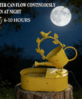 Front view of a yellow solar powered outdoor water fountain with battery backup for garden bird bath yard decor, premium metal water feature for patio and lawn, no hassle run time of 6 to 10 hours at night on sunny days, depicted at night with moon backdrop.