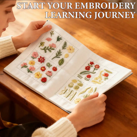 Person browsing Embroidery Stitch Book Kit With 106 Patterns, linen pages open displaying floral designs on wooden table