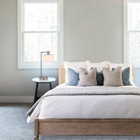 Lit Brushed Nickel USB Desk Lamp With White Fabric Shade next to a bed in a modern bedroom