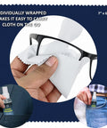 Person cleaning eyeglasses with microfiber cloth using Streak Free Lens Cleaner Spray Kit with two 2oz bottles and cloths.