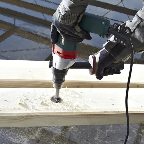 Heavy Duty One Half Inch High Torque Drill With Solid Six Point Seven Amp Motor drilling into wood surface with shavings flying.