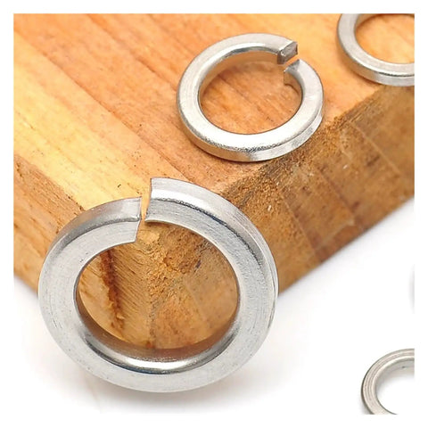 Rock Solid Stainless Steel Split Lock Washers Heavy Duty Elastic Spring Gaskets on wood background for M2 to M30 fit.