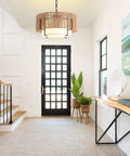 A Straight Up Game Changer 4Light Rattan Chandelier With Linen Drum Shades illuminates the entryway with a boho vibe and soft lighting.