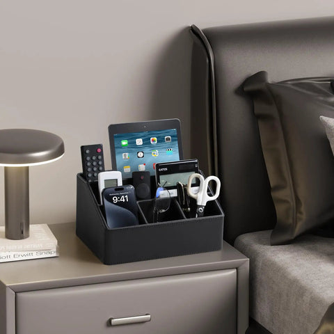 Straight Up Sturdy PU Leather Desk Organizer With Five Compartments Sleek Black Design containing phones and scissors on a bedside table.