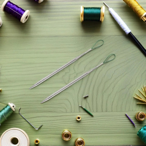 Five Piece Elastic Waistband And Drawstring Threader Set Made From Durable Steel For Dope Effortless Threading In Hoodies Bags And Garments Perfect Tool For Quick Drawstring Insertion And Easy Elastic Band Repairs. Two steel drawstring threaders on green tabletop with spools