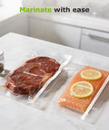Steak and salmon in vacuum-sealed bags with 11 Inch By 150 Foot Vacuum Sealer Bags Roll With Built In Cutter, BPA Free.