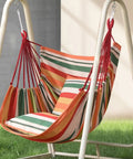 Striped hammock chair on a stand, colorful canvas fabric, suitable for indoor and outdoor use, sturdy frame supports relaxation.