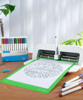 REALIKE 8.5x12 cutting mat for Cricut Joy Xtra, green grip mat with design on white sheet; 12-pack metallic pens beside.