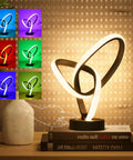 RGB LED Modern Table Lamp With 7 Colors, 10 Light Modes, And 3 Way Dimmable Touch Desk Lamp beside books and vase on a table