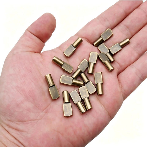 Solid Bronze Shelf Pins 100 Pack Cabinet Pegs For Straight Up Diy Fixes shown in hand, showcasing smooth zinc alloy spoon shapes.