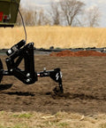 Middle Buster Furrower Attachment For Subsoil Work From Impact Implements in action on farm, tractor hookup visible, durable steel design