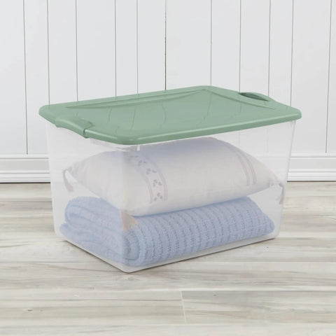 Six Pack Sage Green Storage Bins 66 Quart Clear Stackable Plastic Containers With No Sweat Snap Lock Design Stack Smart For Clothes Moving Garage And Serious Organizing with a pillow and blanket inside.