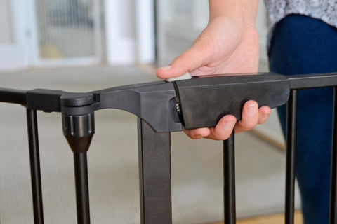 Expandable Extra Wide Baby Gate For Kids And Pets Fits 30 To 90 Inches In Black being adjusted by a hand