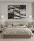 Bedroom with beige bedding, a large abstract triptych, and two crystal pendant lights on either side of the bed.