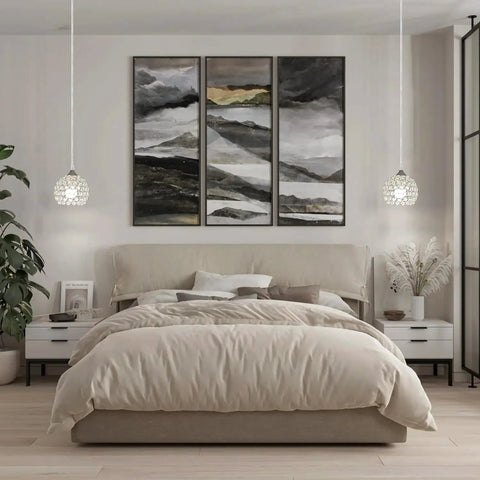 Bedroom with beige bedding, a large abstract triptych, and two crystal pendant lights on either side of the bed.