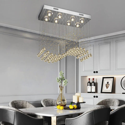 Modern K9 Crystal Chandelier Light Fixture With 8 Lights Raindrop Chandeliers In An S Shaped Flush Mount Ceiling Light That Makes Your Kitchen Island Bedroom And Dining Room Pop, hanging over a dining table in a modern interior setting.