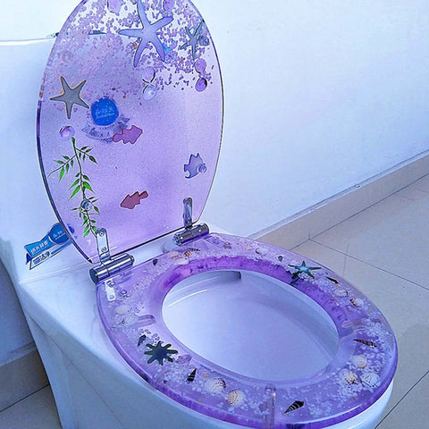 Vibrant Purple Round Resin Toilet Seat With Embedded Sea Shells, Hella Smooth Slow Close Metal Hinge, Tough Four Hundred Pound Capacity with a coastal design.