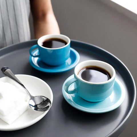 Two blue espresso cups on saucers with a Demitasse Espresso Spoon Set Of 6, Mini Stainless Steel Coffee Spoons, on a tray.