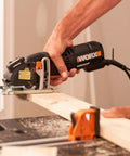 Compact Palm Saw With 3 Amp Motor And 3 3/8 Inch Blade For Clean Cuts Through Wood Aluminum Siding And Tile Ergonomic Thumb Grip Lightweight Rotary Trimmer handles a wood plank.