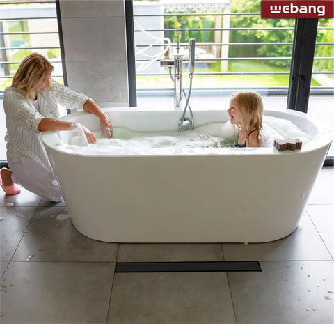 Mother and daughter in a bathtub next to 36 Inch Linear Shower Drain Kit With Reversible 2-In-1 Cover And Tile Insert Grate Removable.