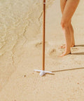 Heavy Duty Beach Umbrella Anchor With Spiral Screw Base Universal Size Fits Most Umbrellas Perfect For Sand Or Grass Keeps Your Beach Shade Steady In Windy Conditions White used on sandy beach.