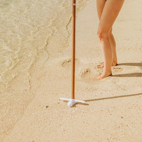 Heavy Duty Beach Umbrella Anchor With Spiral Screw Base Universal Size Fits Most Umbrellas Perfect For Sand Or Grass Keeps Your Beach Shade Steady In Windy Conditions White used on sandy beach.